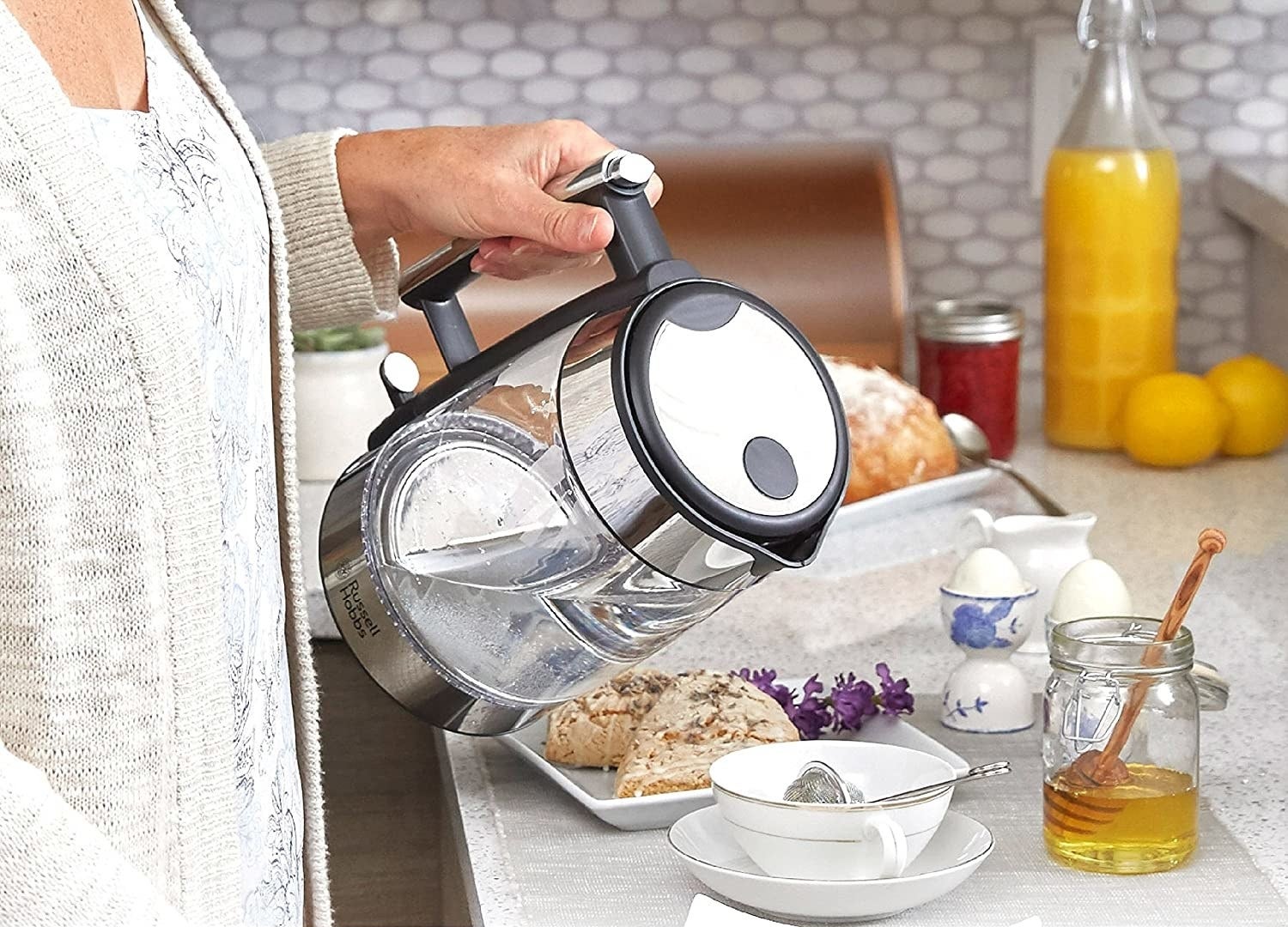 A person using the kettle to make themselves a fresh cup of tea