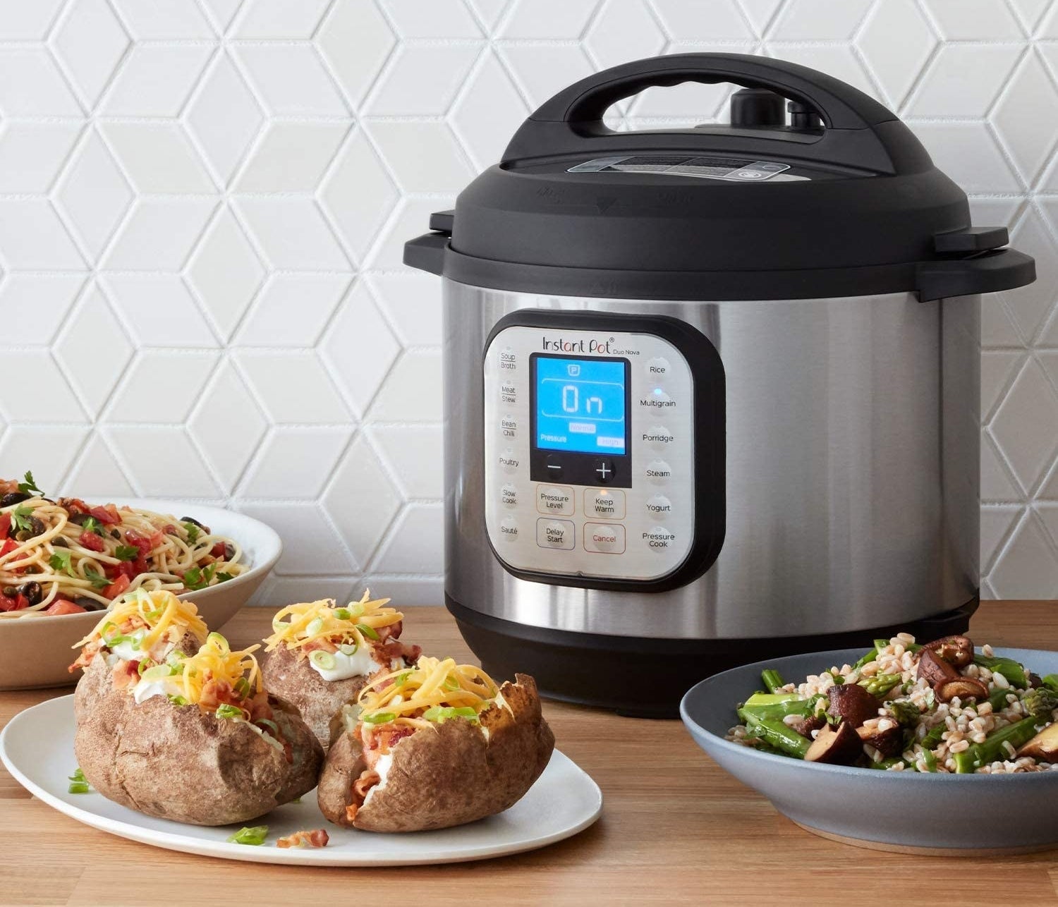 An Instant Pot next to plates of baked potatoes and other delicious meals