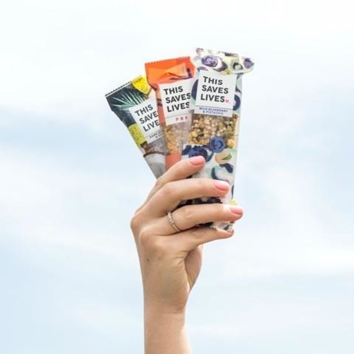 a hand holding up three different flavored bars 