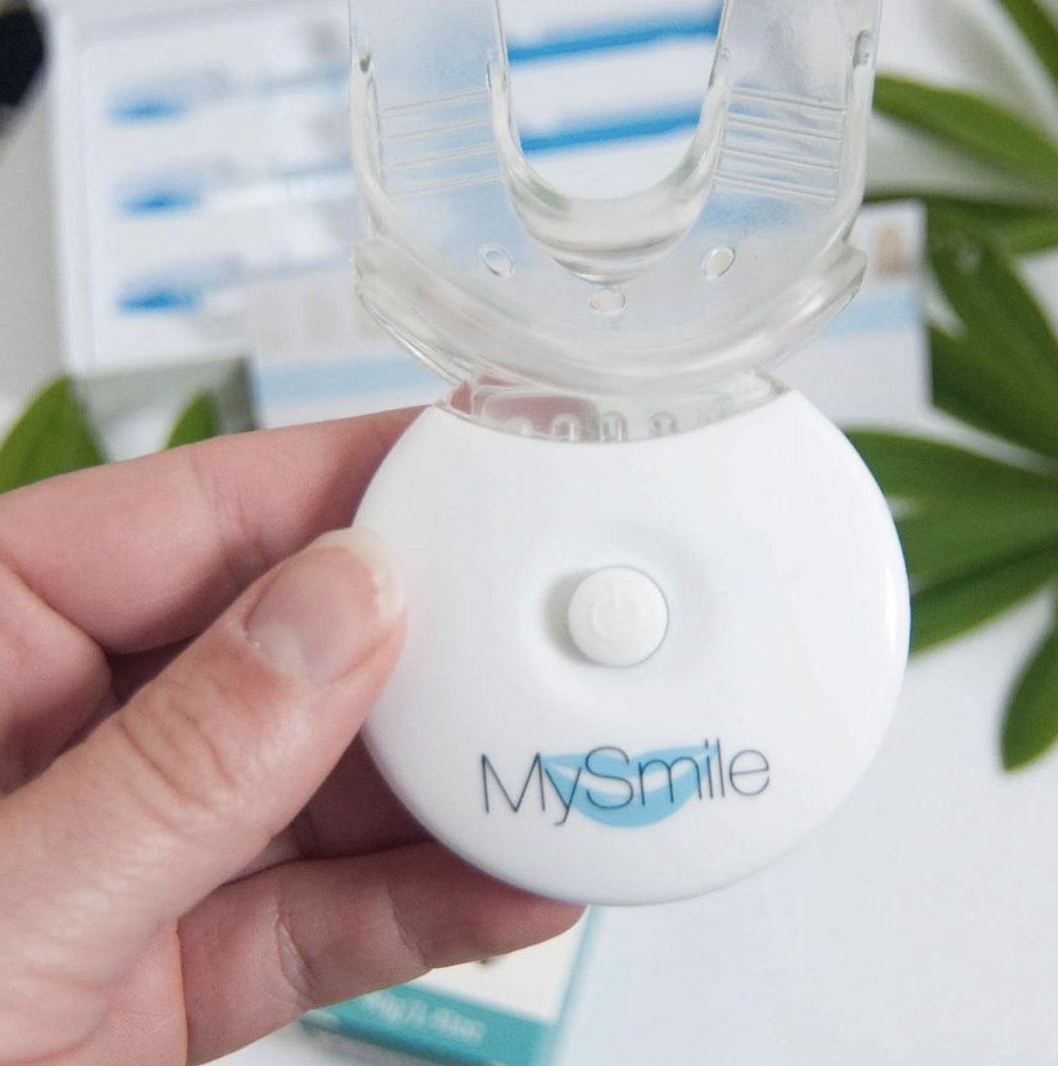 A hand holding the MySmile light