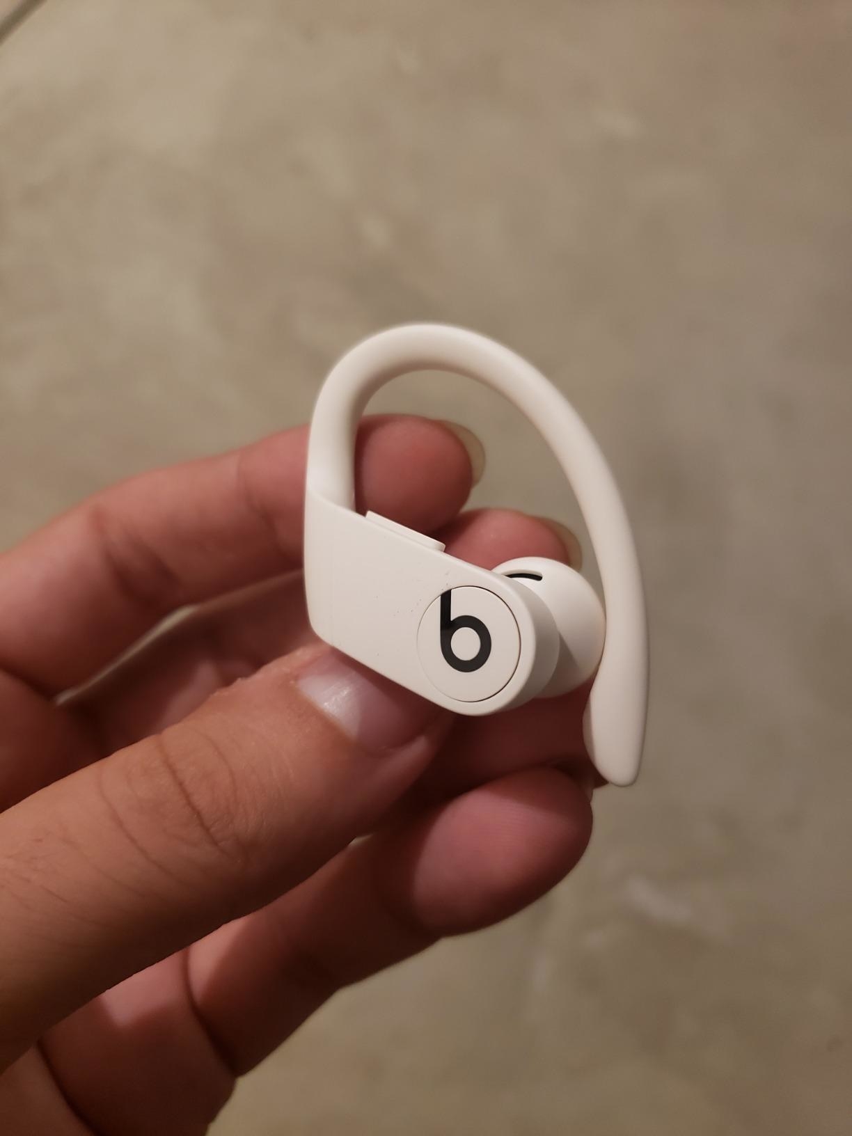 Reviewer holding the white earbud