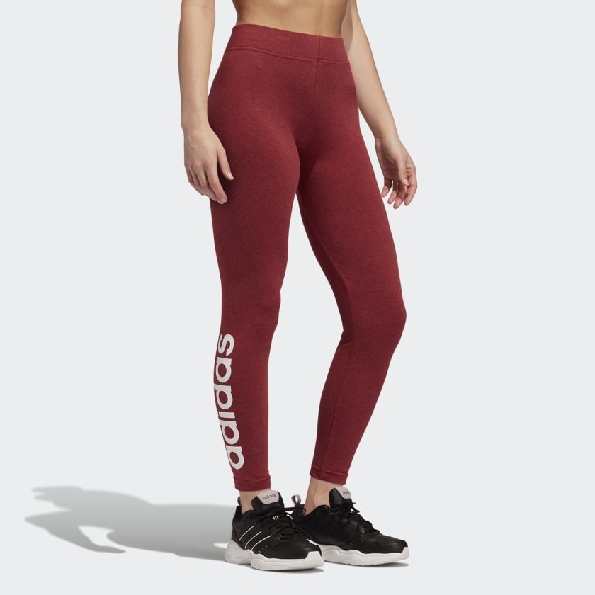 A person wears a pair of tights with the word Adidas on the side of the calf