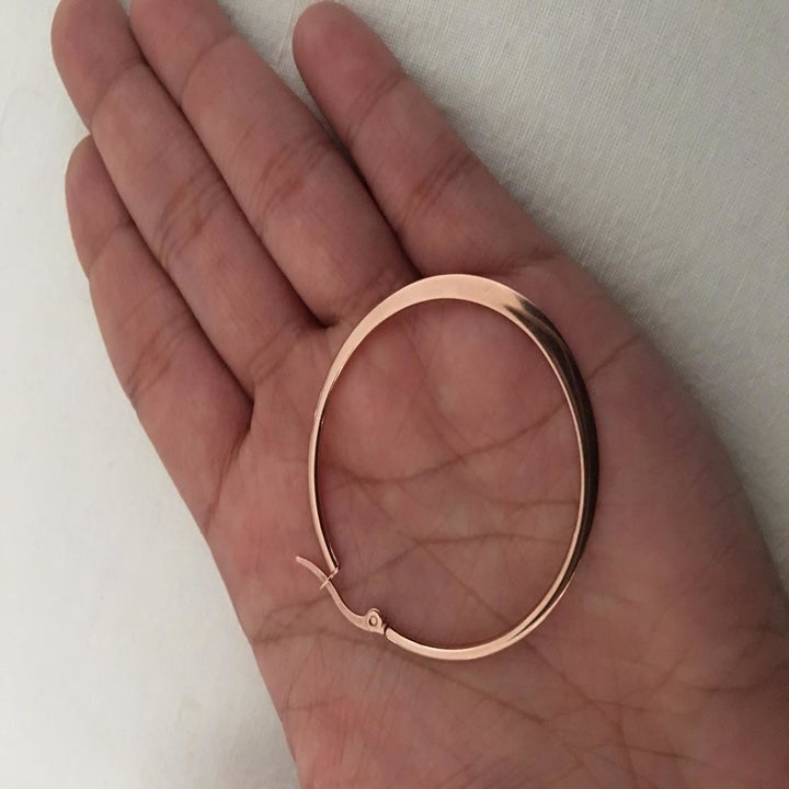 Reviewer holding the gold hoop, which has a flat edge rather than a rounded one