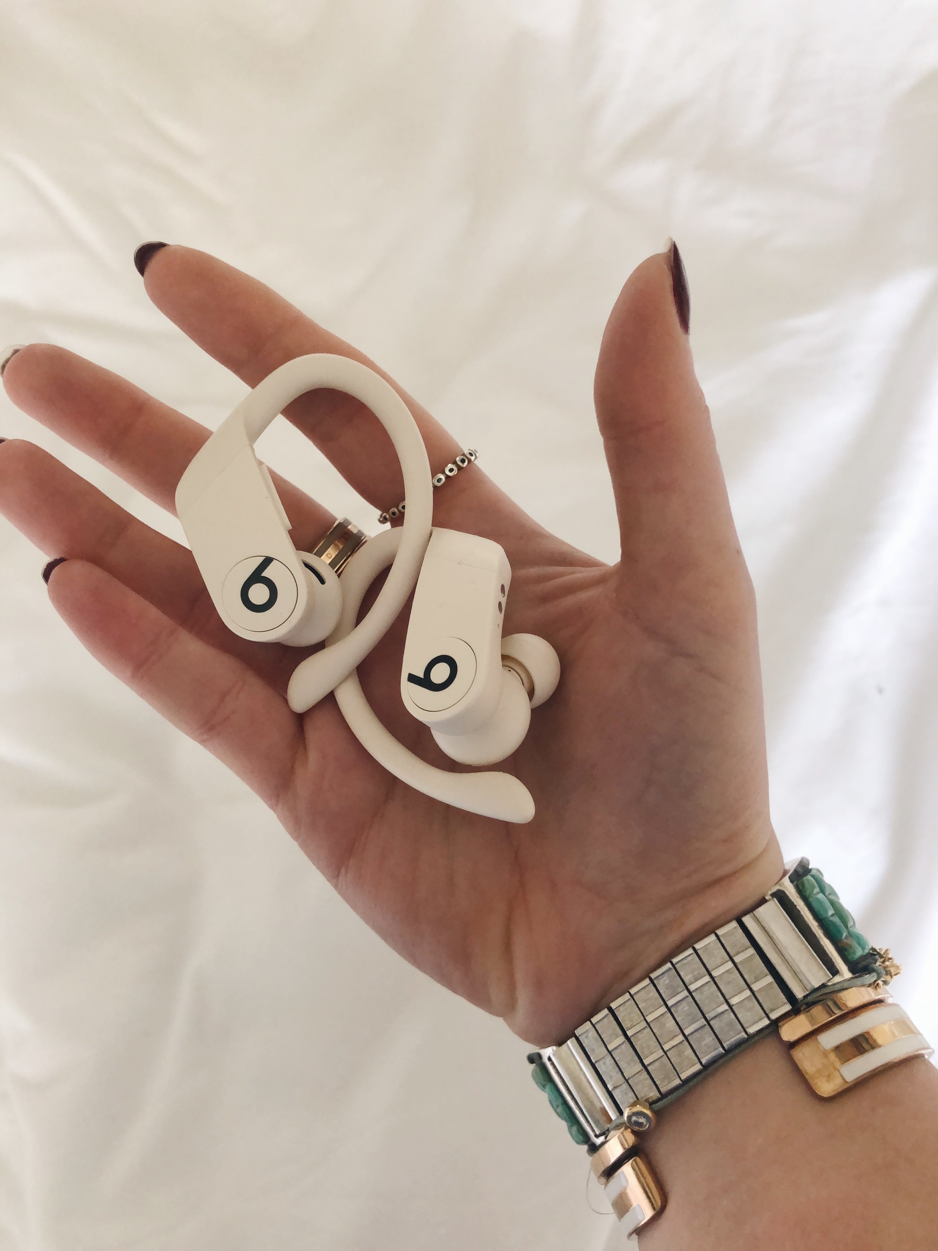 BuzzFeed Shopping reviewer holding the headphones in white