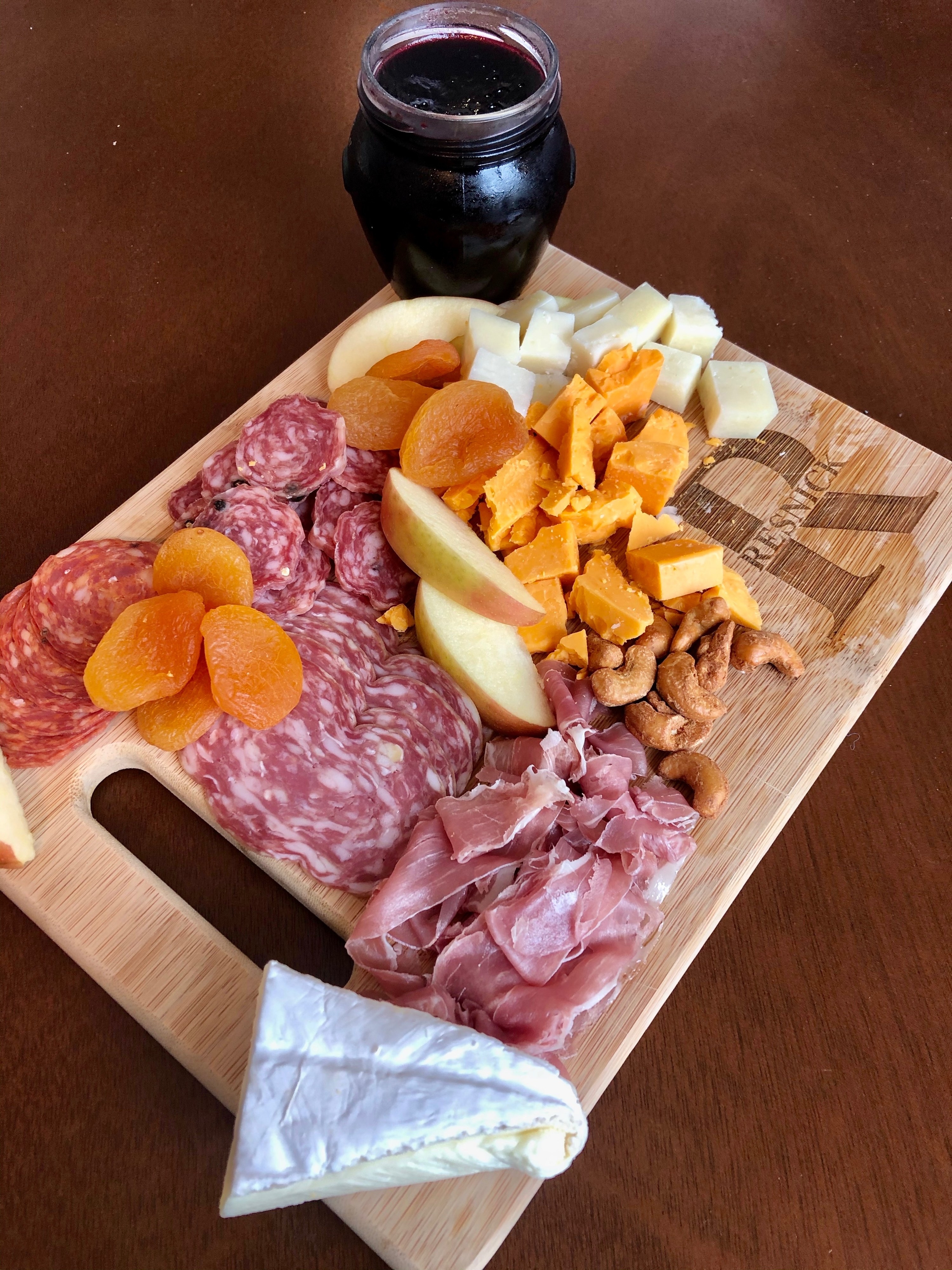 a custom carving board with a cheese and meat spread on it