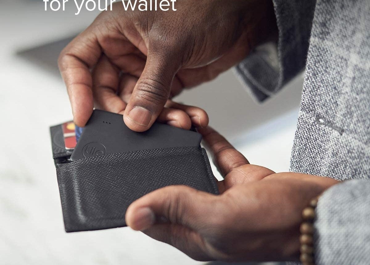 man putting tile in his wallet