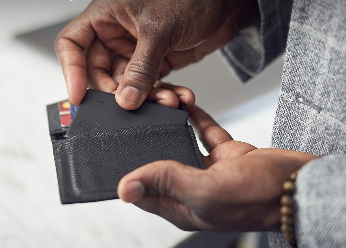 man putting tile in his wallet