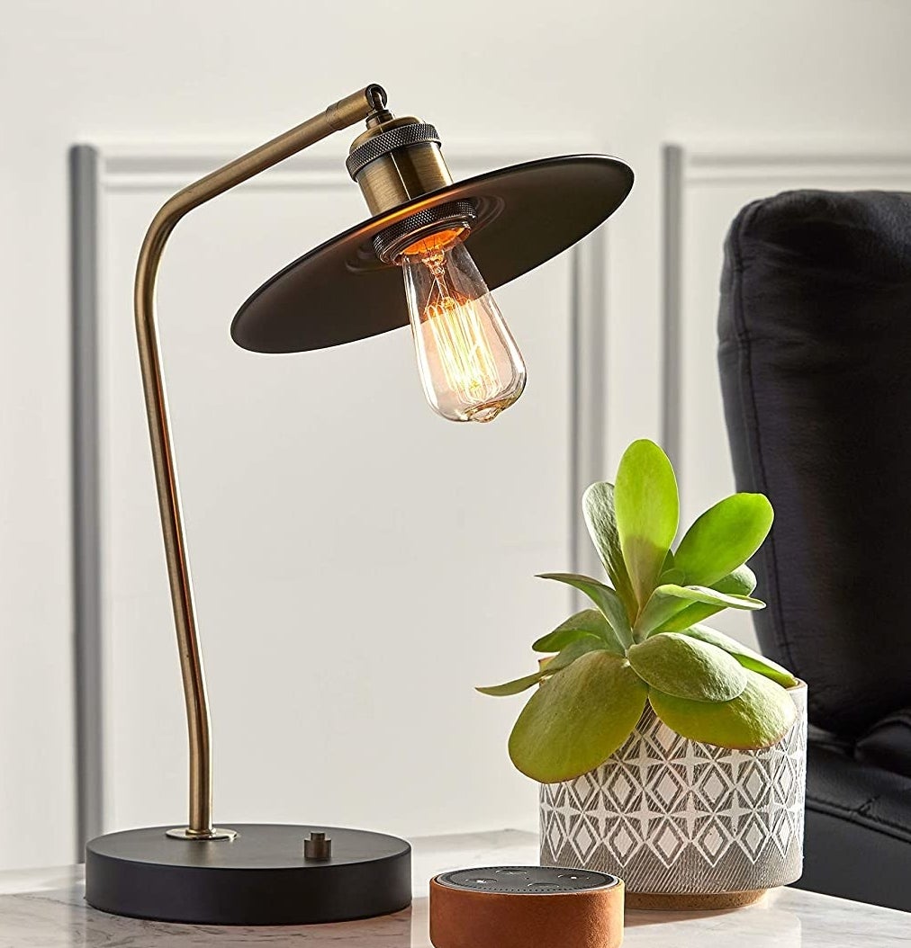 A ceramic planter on a side table with a plant in it