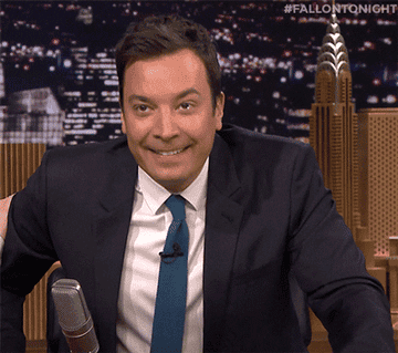 Jimmy Fallon wearing a suit and blue tie making a fist and saying &quot;yes!&quot;