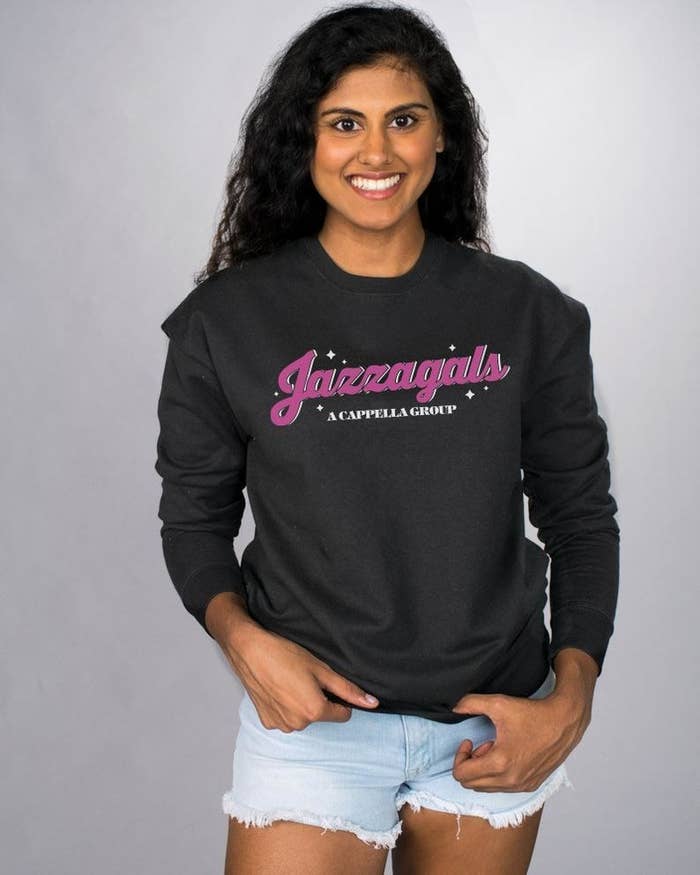 a model wearing a black sweatshirt with jazzagirls on it in pink