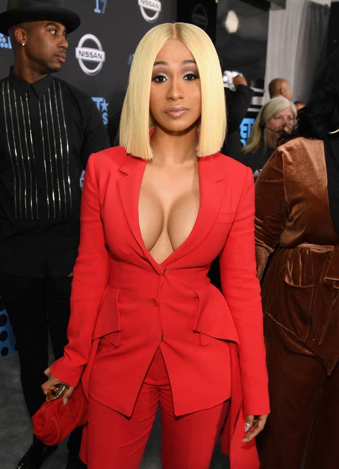 Cardi B wearing a suit and blonde wig
