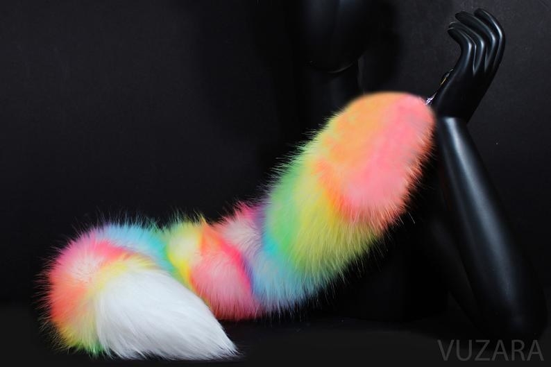 a manikin hand holding onto the pastel rainbow tail