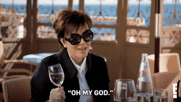 GIF of Kris at a restaurant, holding a glass of water with the caption &#x27;Oh My God&#x27;