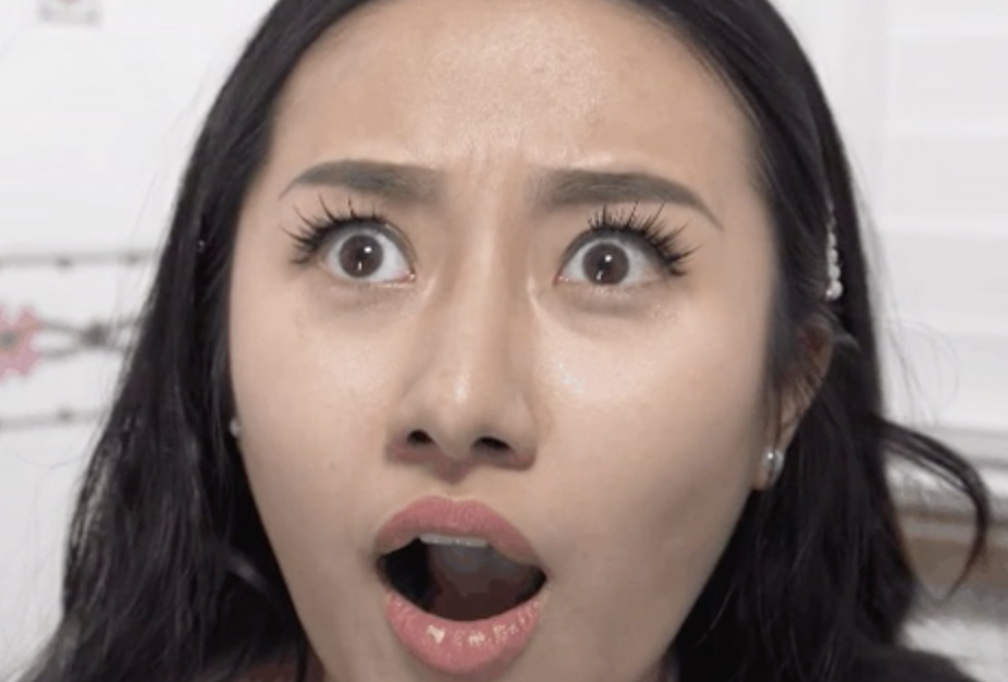 A woman's mouth is open and eyes are wide in shock