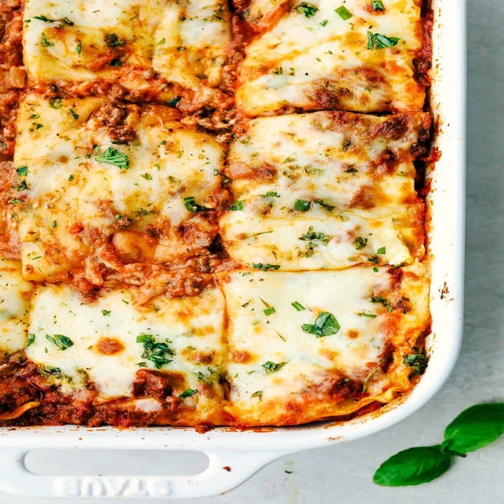 A lasagna cut into slices in a baking dish.