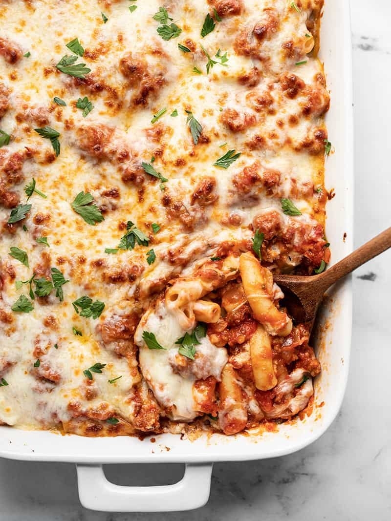 A baking dish of baked ziti with lots of melted cheese.