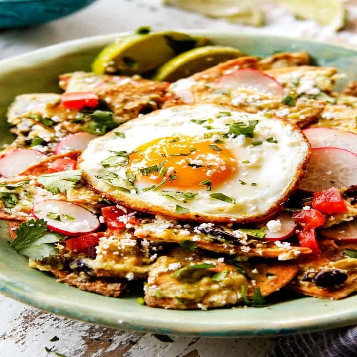 A plate of chilaquiles with radishes and fried egg.