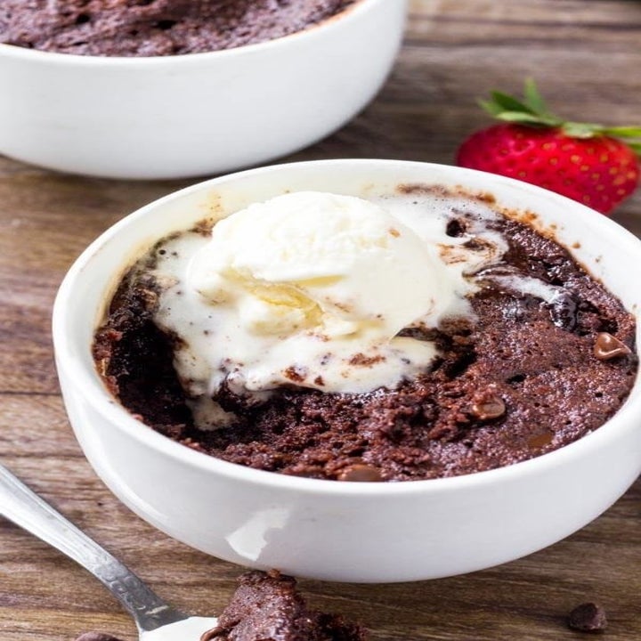 A chocolate mug cake with a scoop of ice cream on top.