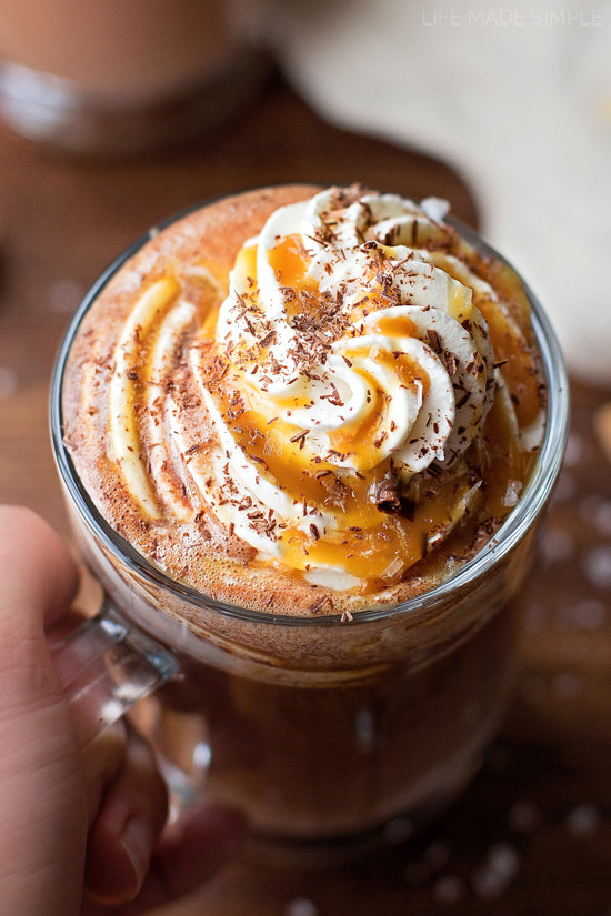 A mug of rich hot chocolate with whipped cream and caramel swirl topping.