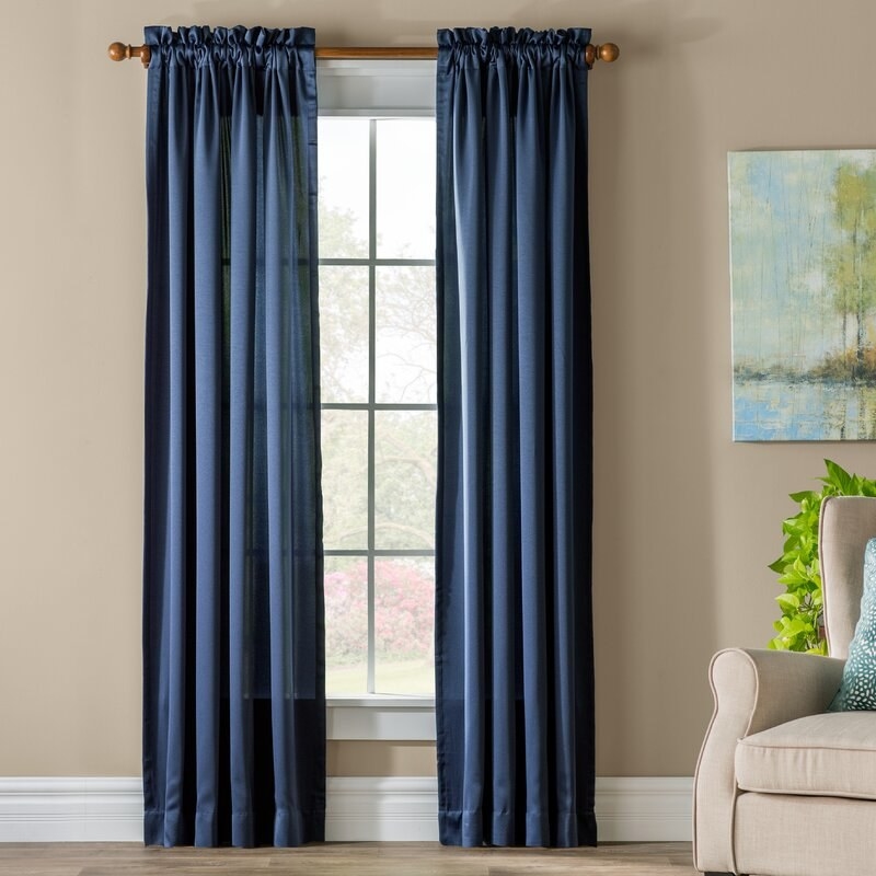 navy room-darkening curtains in from of a window in a living room