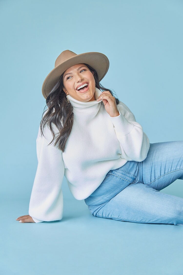 Model wearing a white turtleneck sweater