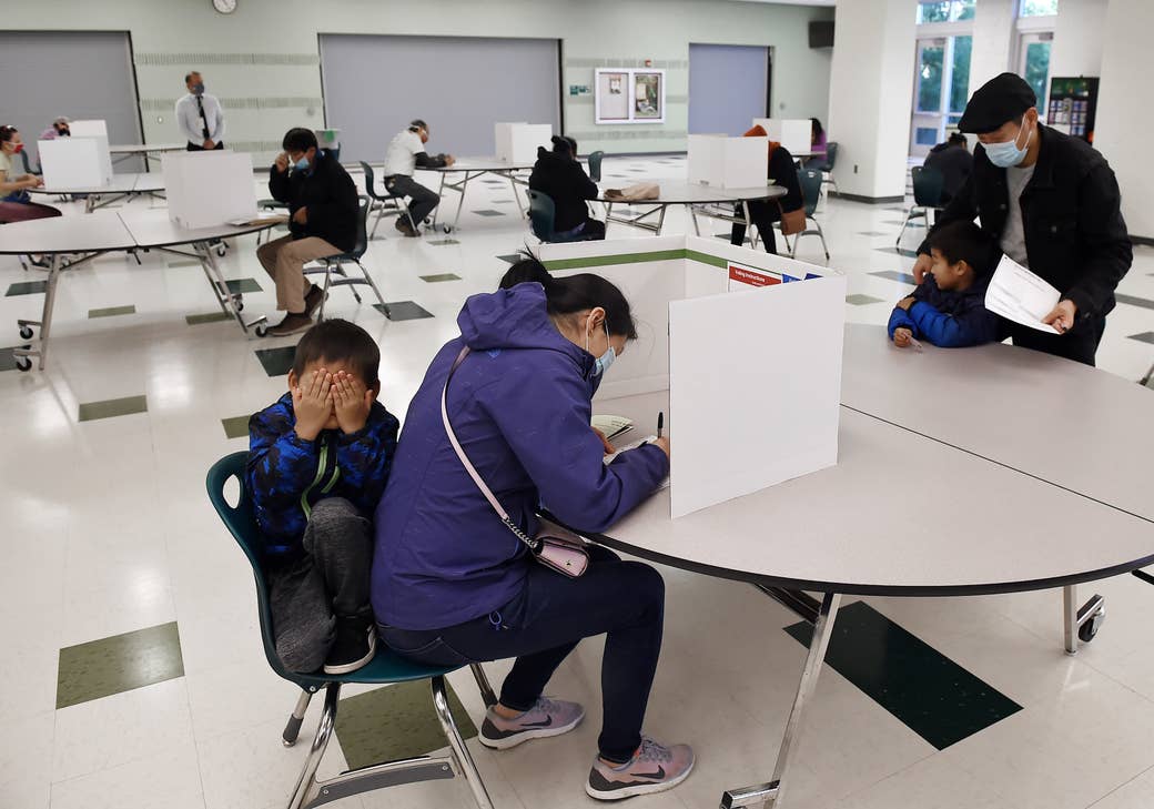 Child covers his face as his mom votes