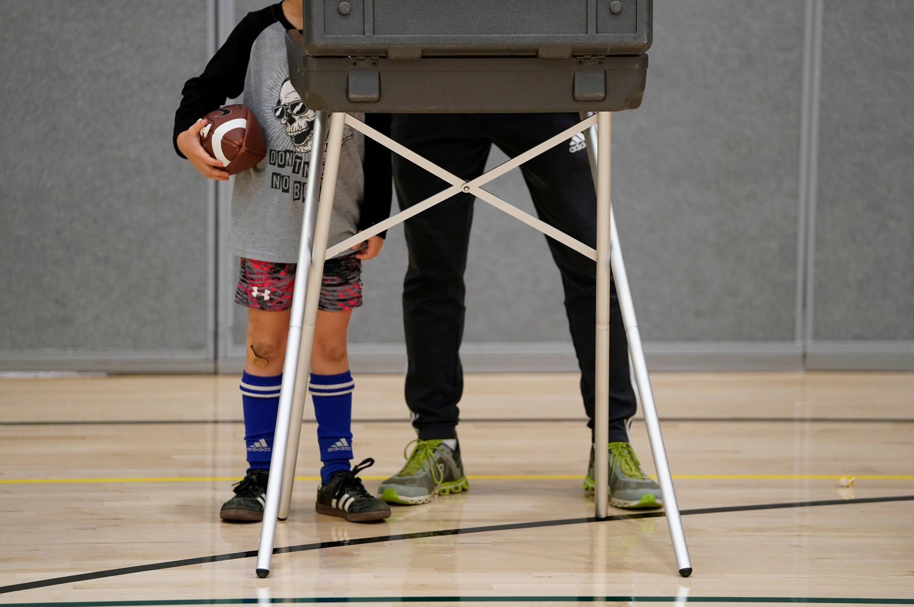 Boy in soccer gear next to his father as he cotes