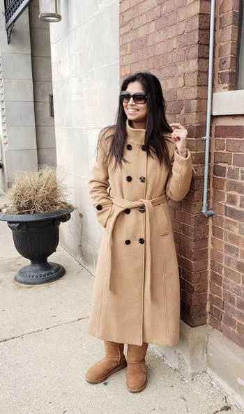 A reviewer wearing the coat in tan