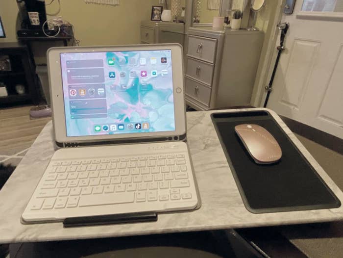 reviewer photo showing lap desk on their bed with an iPad and mouse resting on it 