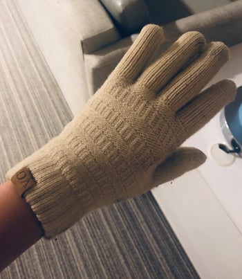 Reviewer showing the cream gloves on their hand