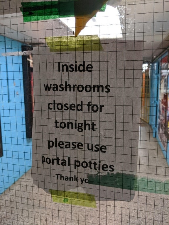 picture of a sign that misspells porta-potties as portal potties