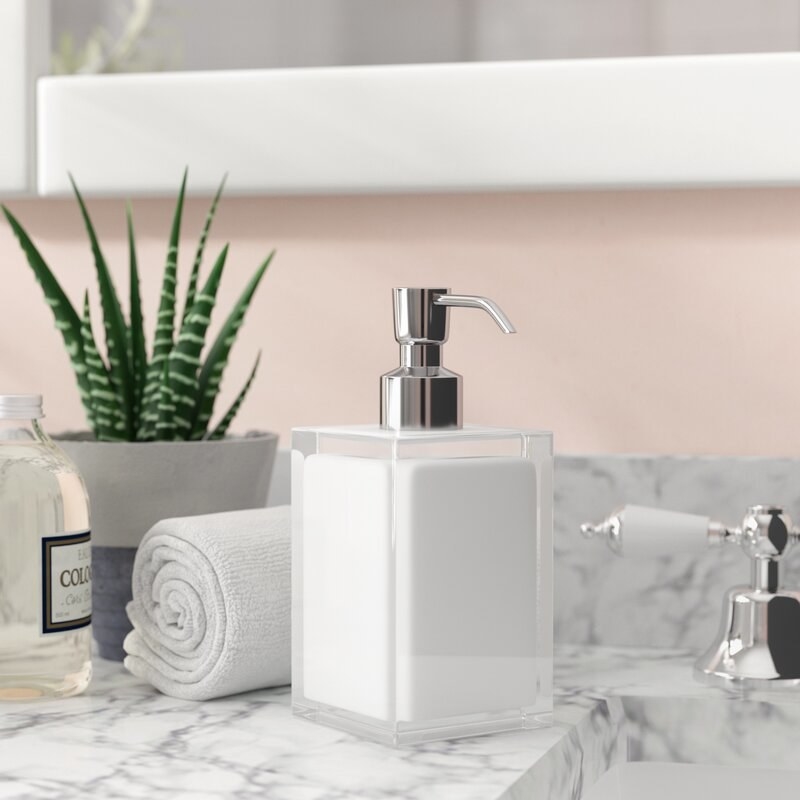 a white soap dispenser on a counter top