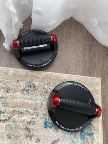 Reviewer pic of the two push-up bars on the floor of their bedroom