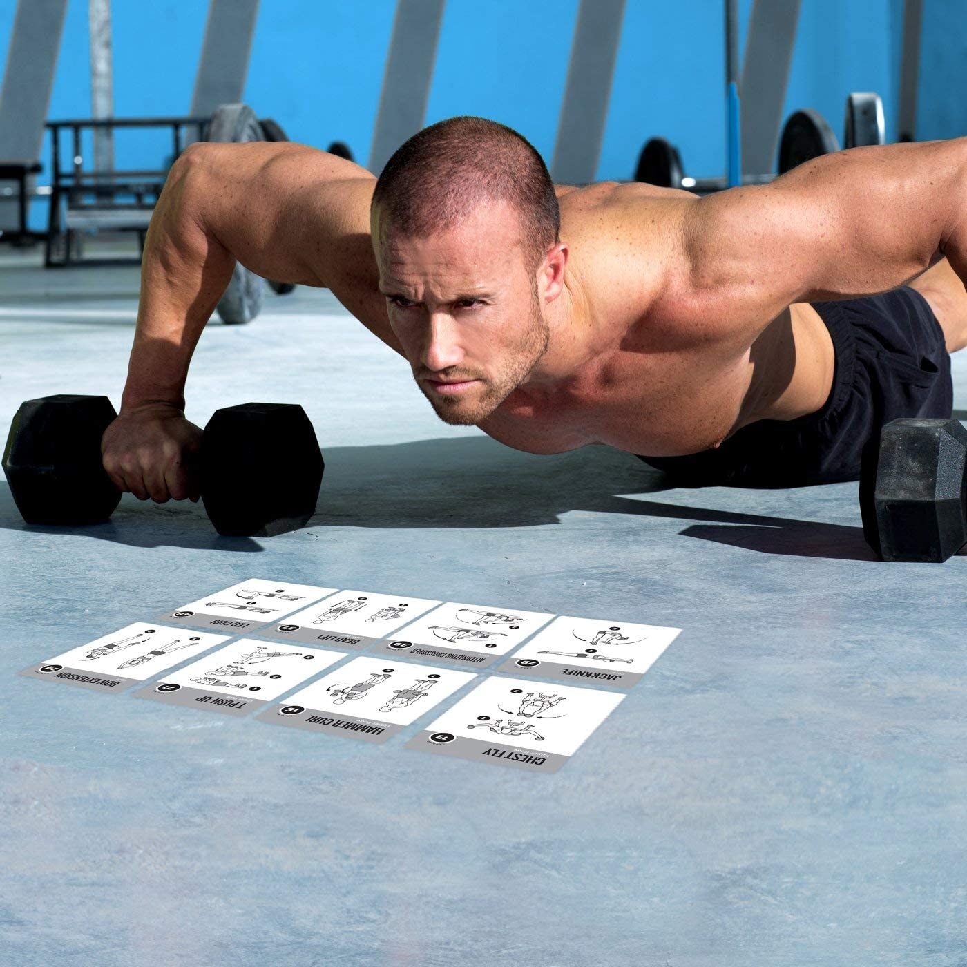 Model goes into push-up position with weights in front of a stack of exercise cards