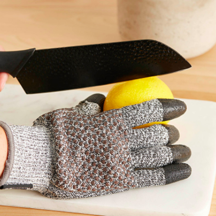 A person wearing the glove while slicing a lemon
