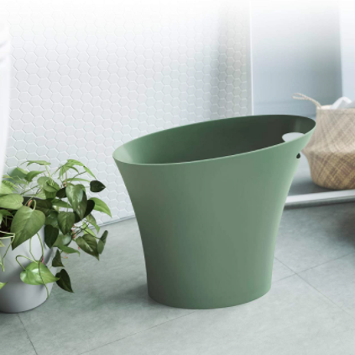 The thin wastebasket in a bathroom
