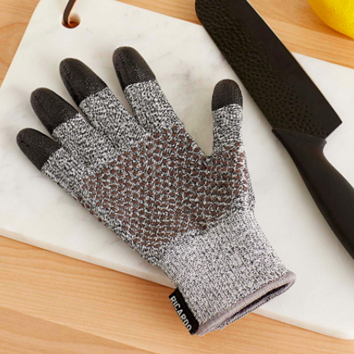 A flatlay of the glove next to a sharp knife