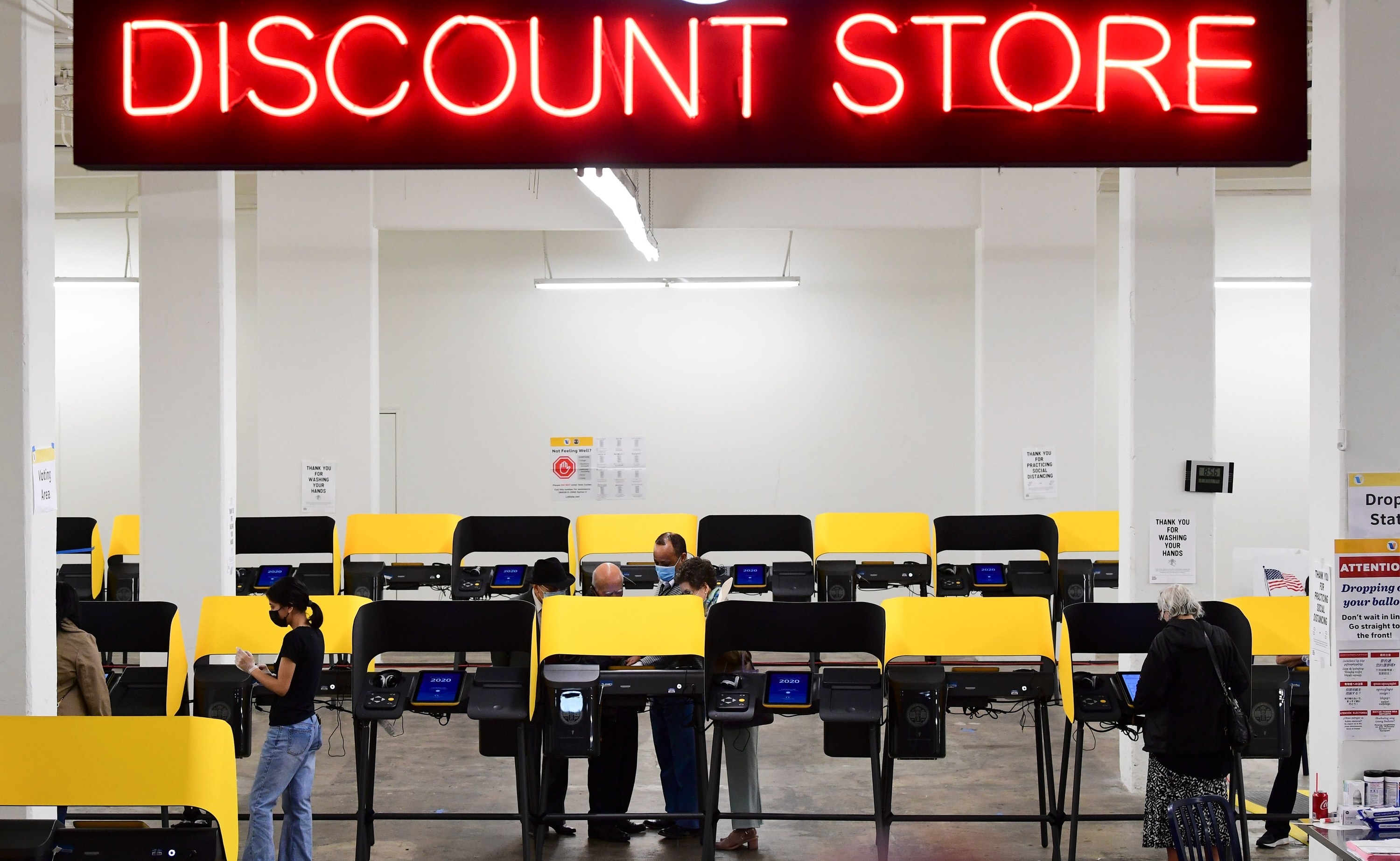 People voting underneath a giant discount sign. 