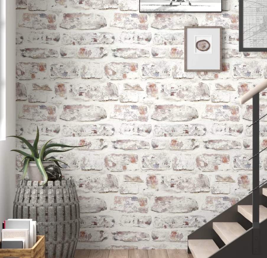 White and brown brick wallpaper wall with staircase on the right and large planter and book box on the left