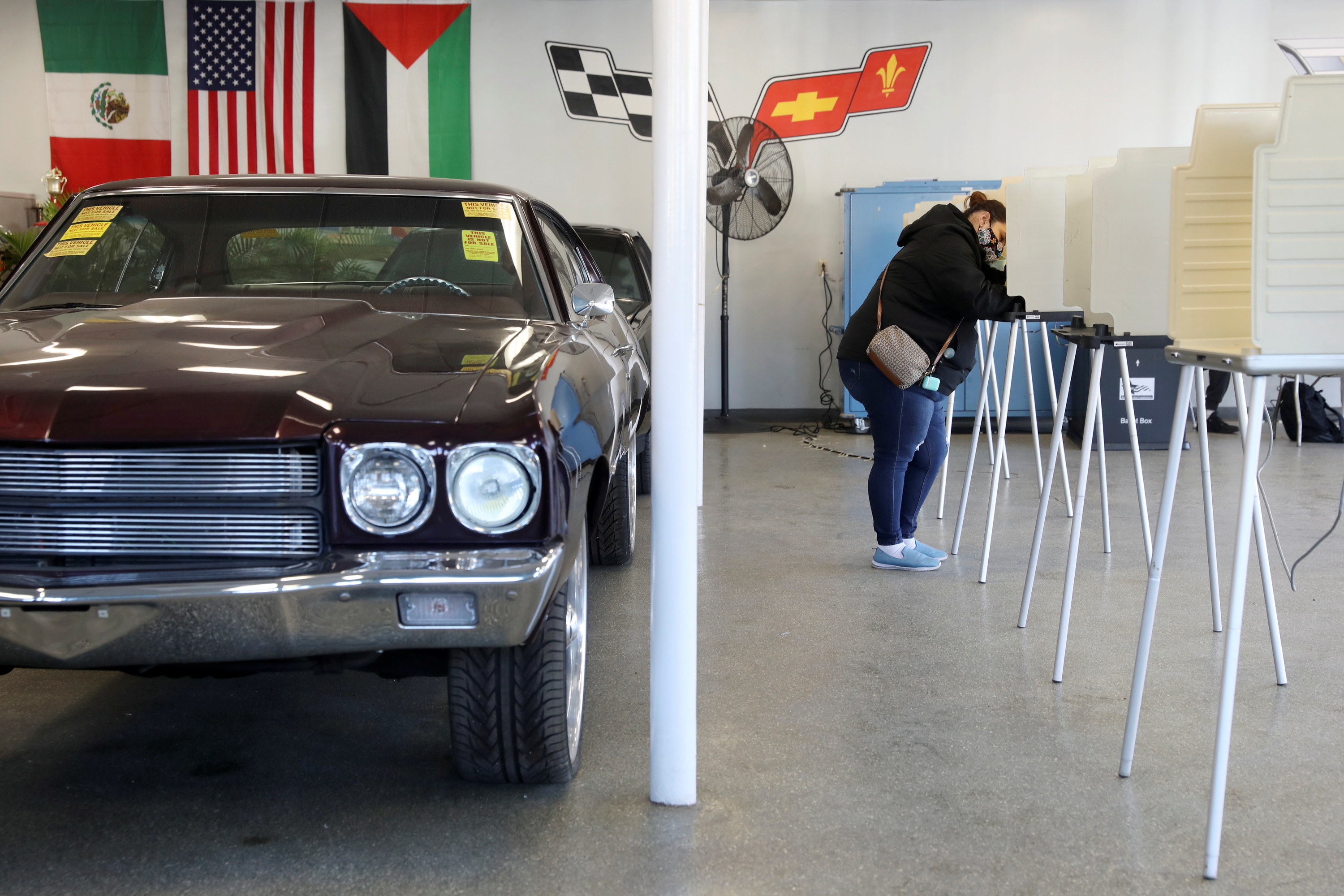 Woman voting at a polling station in an Auto Garage. 