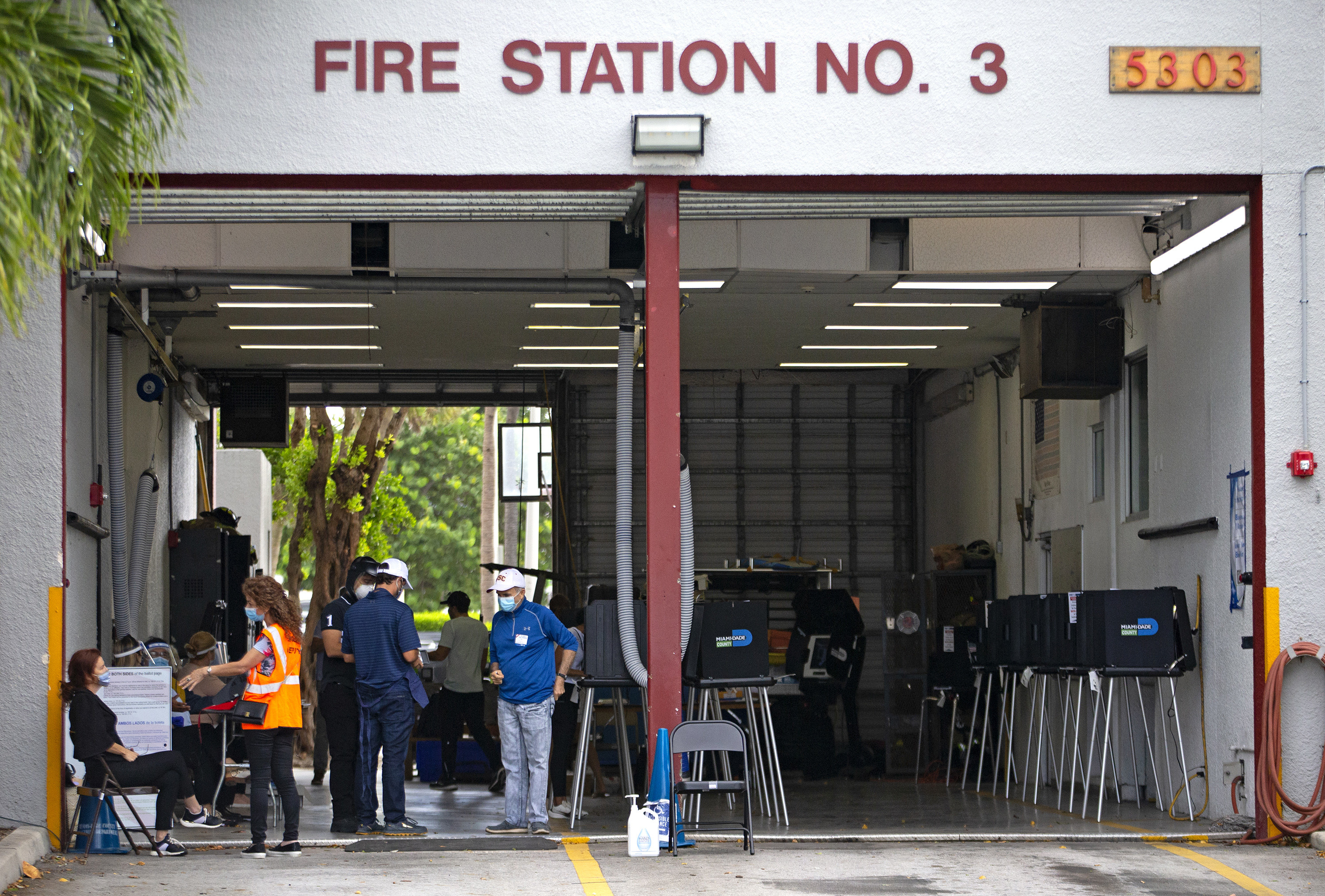 Voters and ballot boxes at a fire station.