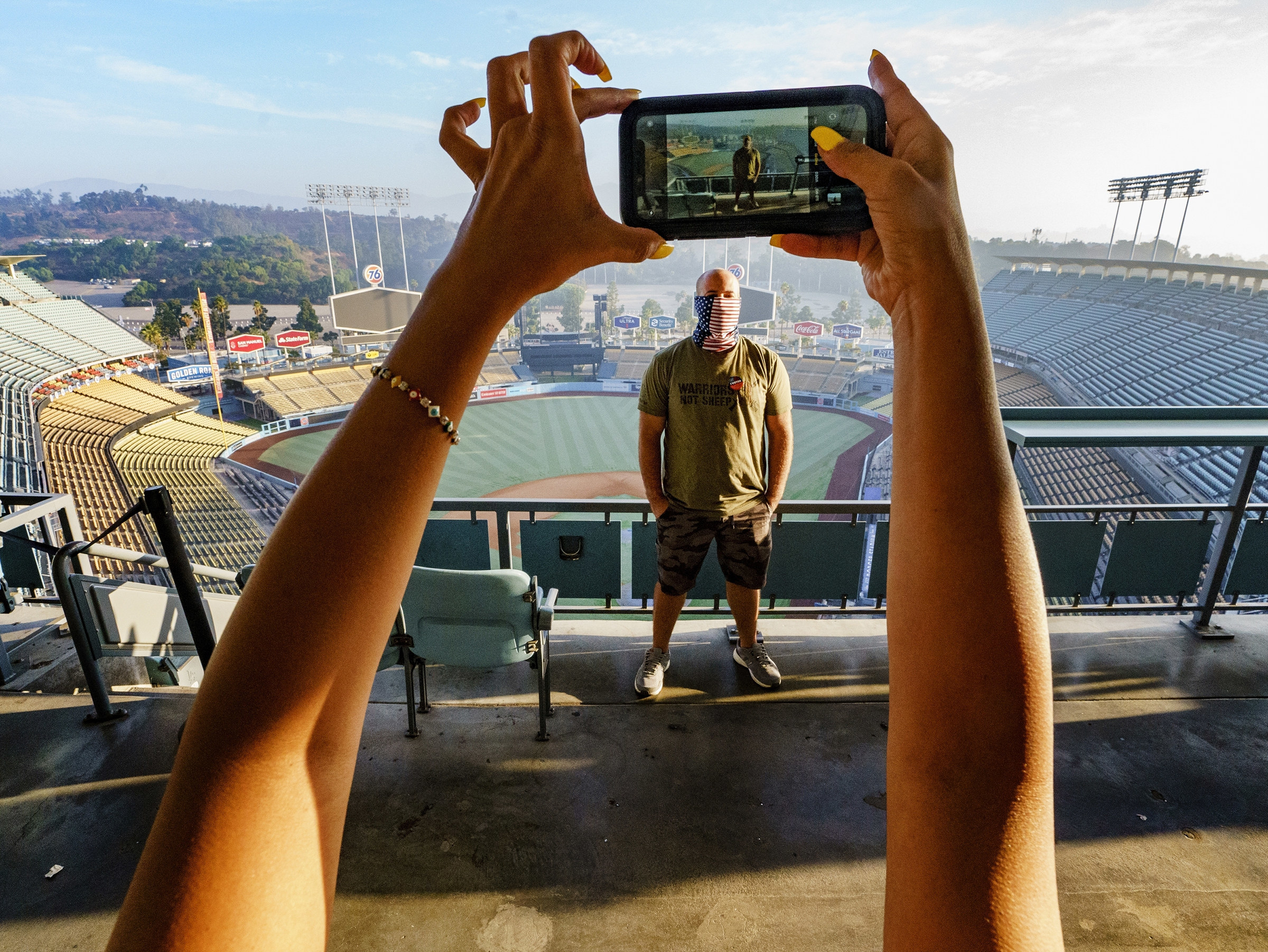 Woman photographing a man at Dodgers Stadium. 