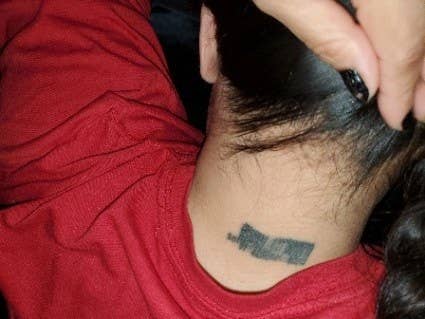 A very blurred barcode tattoo on the back of someone&#x27;s neck