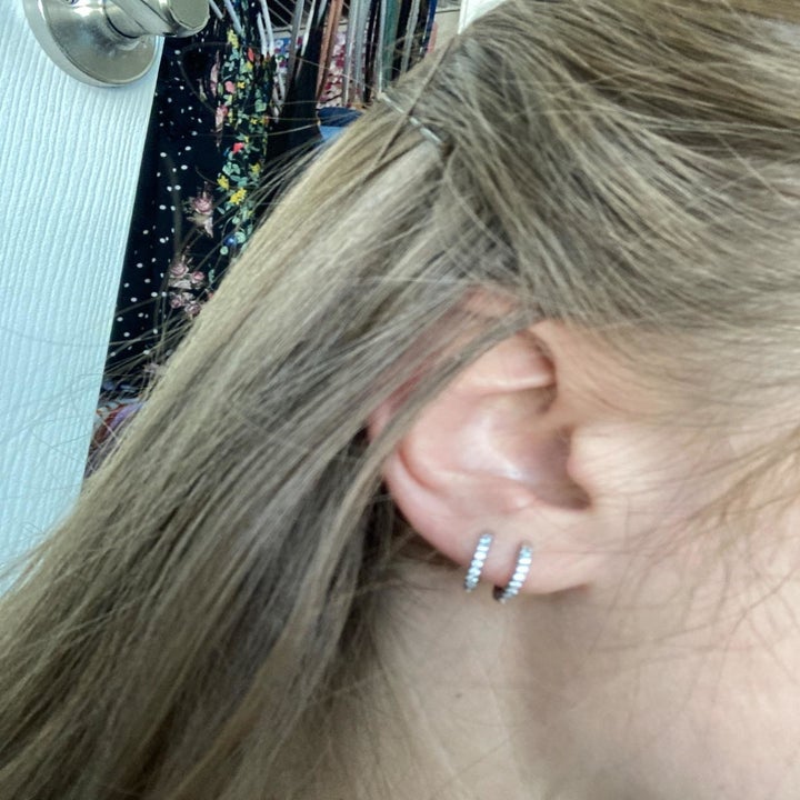 Two huggie hoop earrings on reviewer's ear
