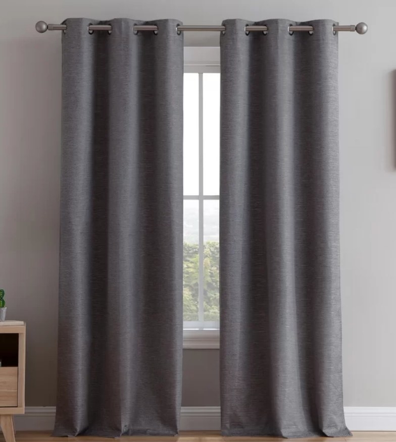 Long dark gray curtains on metal curtain bar over window 