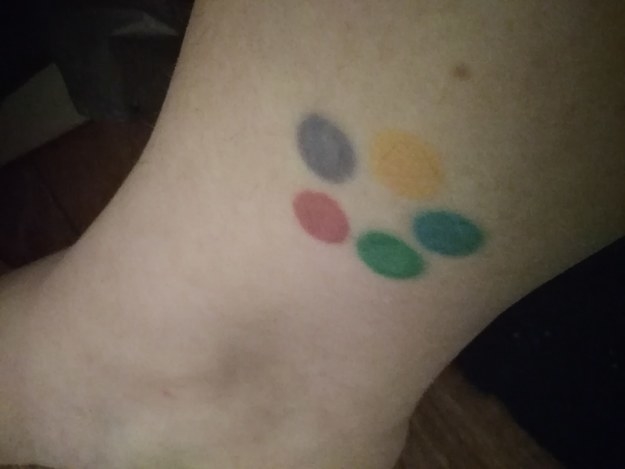Five dots, in yellow, blue, green, red, and purple, in a circle on someone&#x27;s ankle