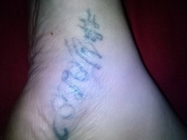 A very faded tattoo that says, &quot;#YOLO&quot; in faded black script on someones ankle