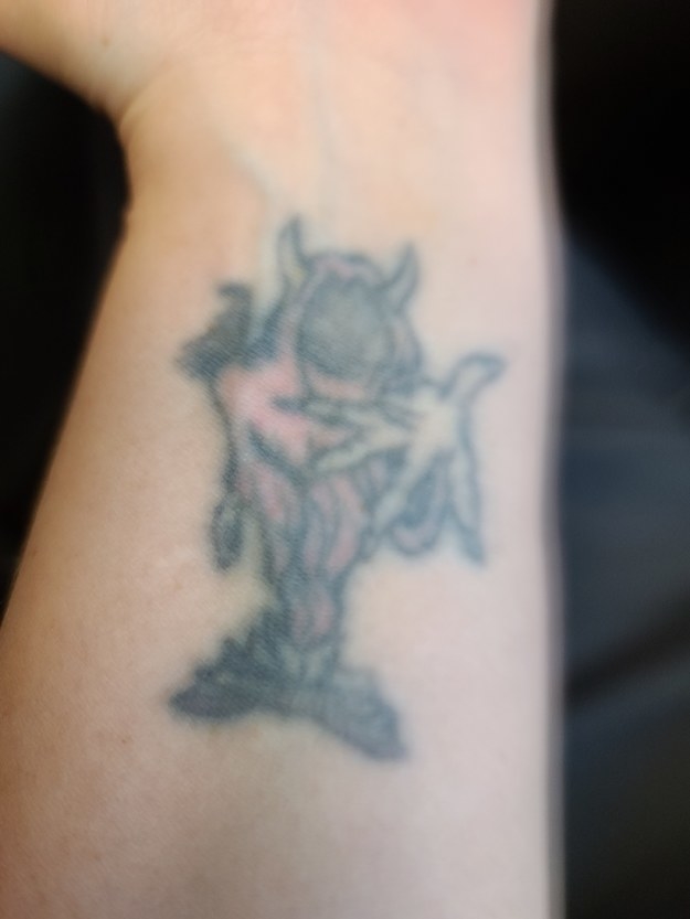 A faded Hatchetman tattoo on the inside of someone&#x27;s wrist