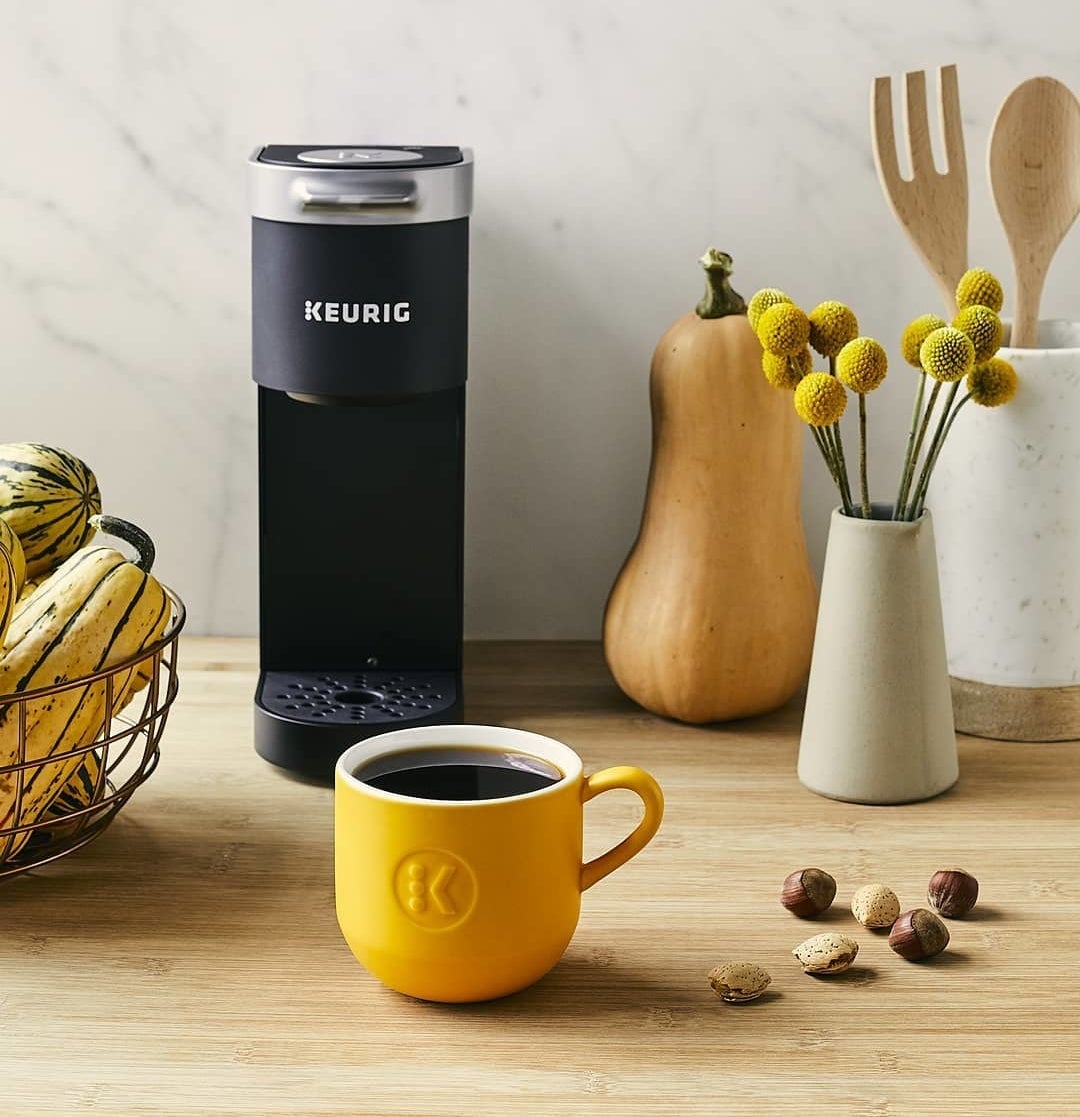 A cup of coffee beside a Keurig K-Mini