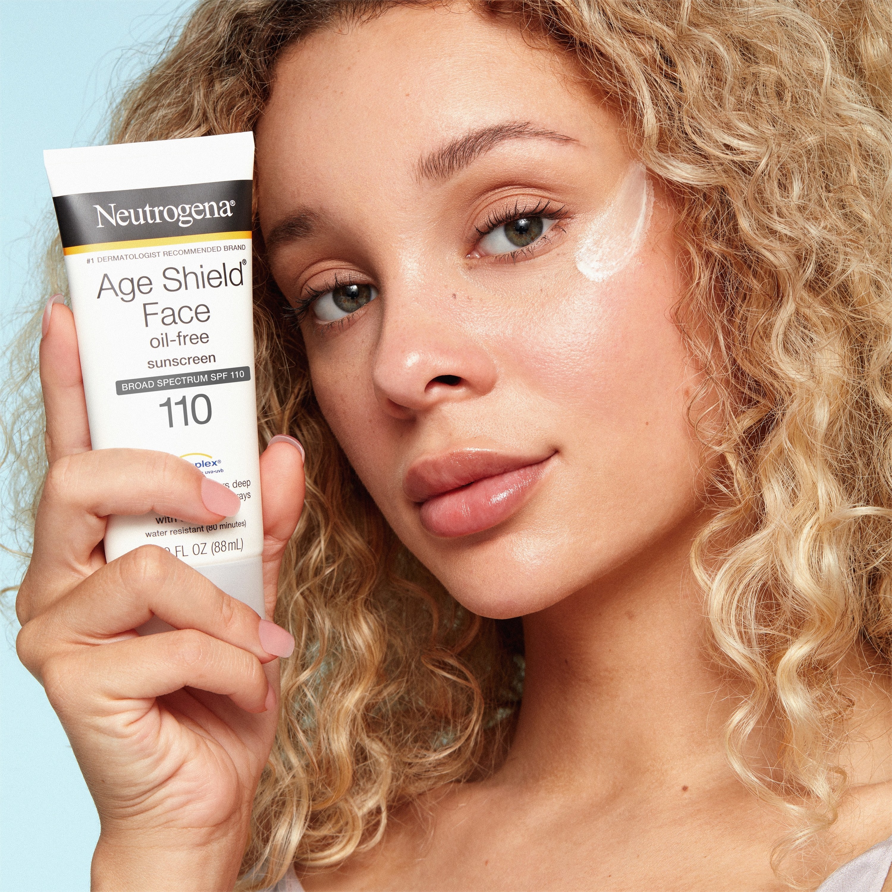 A model holding the sunscreen tube